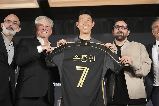 손흥민(가운데)이 7일 열린 미국 메이저리그사커(MLS) 로스앤젤레스(LA) FC 입단 기자회견에서 LA FC 공동 구단주인 베넷 로즌솔(왼쪽), 브랜던 벡과 함께 등번호 7번과 자신의 이름이 한글로 새겨진 유니폼을 들고 기념 촬영을 하고 있다. 로스앤젤레스=AP 뉴시스