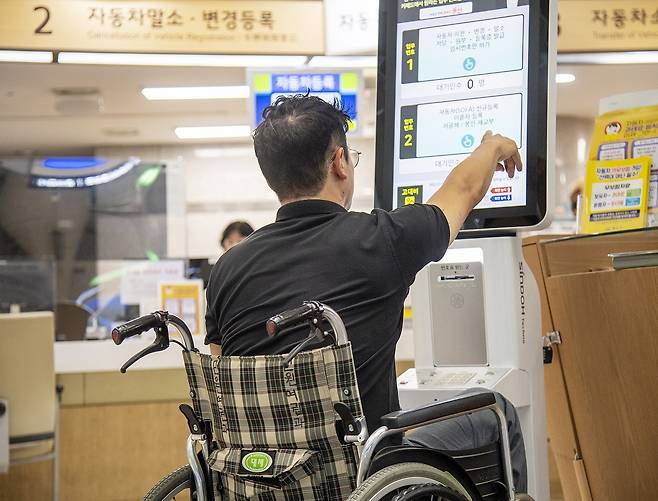 서울 용산구청  자동차등록팀 민원창구 앞에 설치된 유니버설 디자인 키오스크를 한 주민이 사용하고 있다. 용산구 제공