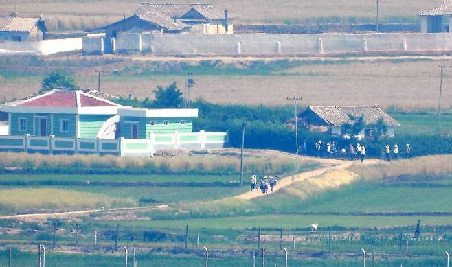 North Koreans are seen in Hwanghae Province, a region that borders South Korea, on June 12. The photo was taken from an observatory in Incheon. [YONHAP]