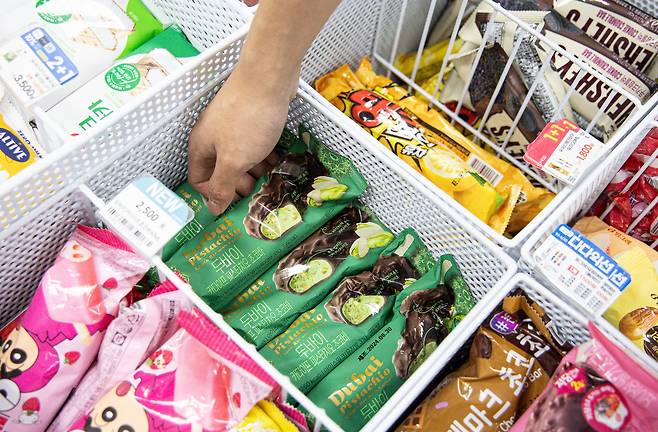A person reaches into an ice cream freezer at a convenience store in Seoul. [NEWS1]