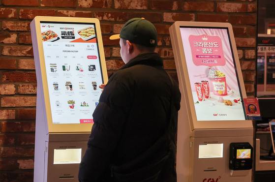 A moviegoer buys tickets at a kiosk set up at a cinema in downtown Seoul on March 27. [NEWS1]