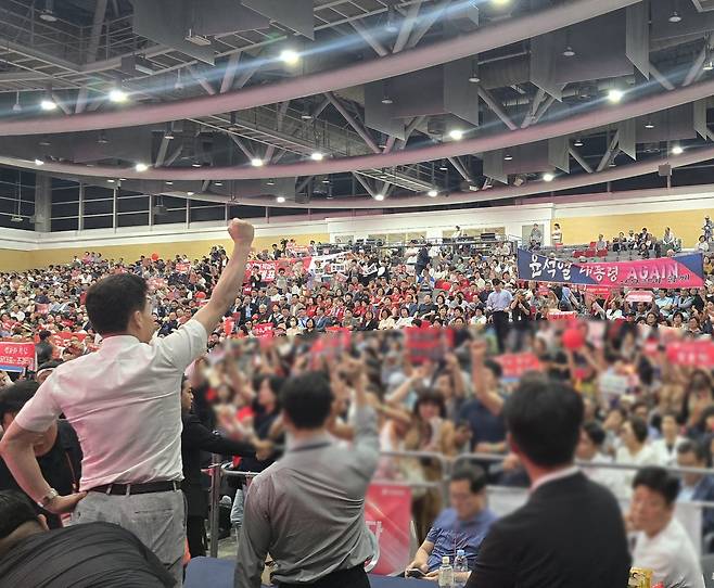 8일 대구 엑스코에서 열린 국민의힘 전당대회 합동연설회에서 조경태 당대표 후보의 연설 도중 의자 위에 올라 청중들에게 자신의 팔을 들어보이는 유튜버 전한길씨. 이에 호응하는 지지자들이 든 현수막에는 ‘윤석열 대통령 AGAIN’이라고 적혀 있다. 이지안 기자