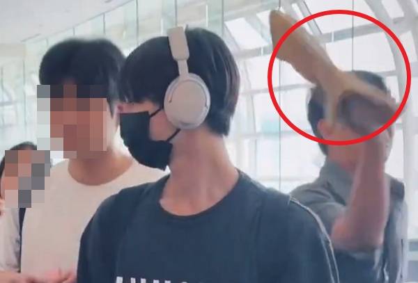 그룹 엔하이픈의 매니저가 공항에서 일부 행인을 폭행하는 듯한 장면이 포착돼 논란이 일었다. 사진은 엔하이픈 멤버 정원 옆으로 매니저가 행인을 폭행하는 듯한 장면. /사진=엑스(X·옛 트위터) 캡처