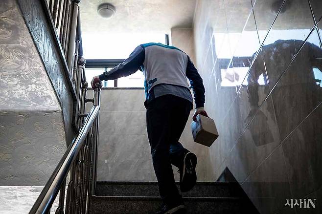 경기도 한 우체국 집배원이 할당된 물량을 배달하기 위해 계단을 오르는 모습. ⓒ시사IN 신선영