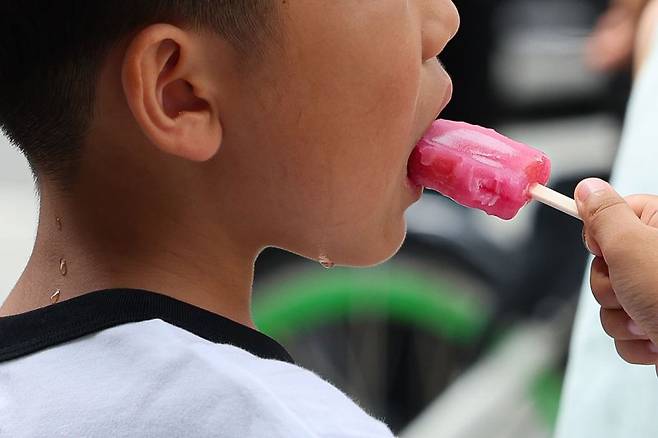 서울지역에 이틀째 폭염주의보가 지속중인 1일 서울 종로구 광화문광장 인근에서 어린이가 땀을 흘리며 아이스크림을 먹고 있다. 뉴시스
