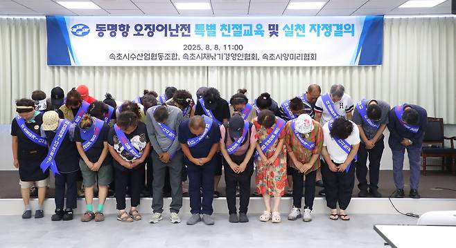 Vendors at the Dongmyeong Port Squid Market in Sokcho, Gangwon Province, hold a meeting on Friday at the National Federation of Fisheries Cooperatives in Sokcho to apologize for a recent customer service dispute and to pledge measures to prevent recurrence. (Yonhap)