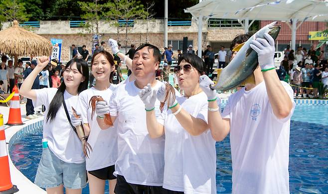 울릉도 서면 남양 해수풀장에서 개최된 방어맨손잡기에 일가족 방어와 오징어를 잡고 즐거워하고 있다. /김두한 기자