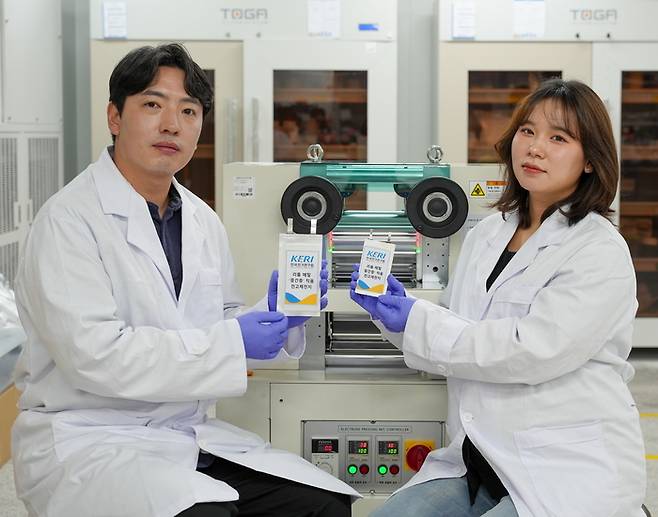 한국전기연구원 전지소재·공정연구센터 남기훈 박사(왼쪽)와 김가람 연구원이 중간층을 만드는 롤프레스 장비 앞에서 성과물을 소개했다.