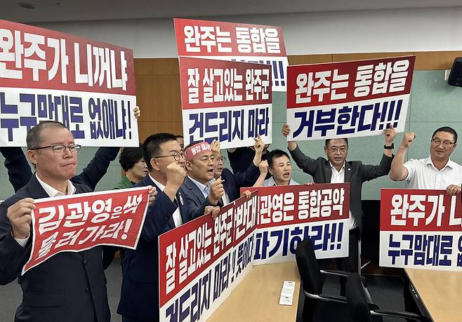 2025년 7월21일 전북특별자치도청에서 열린 완주·전주 통합 관련 기자회견에서 완주군의원들이 통합 반대 팻말 시위를 하고 있다. 연합뉴스