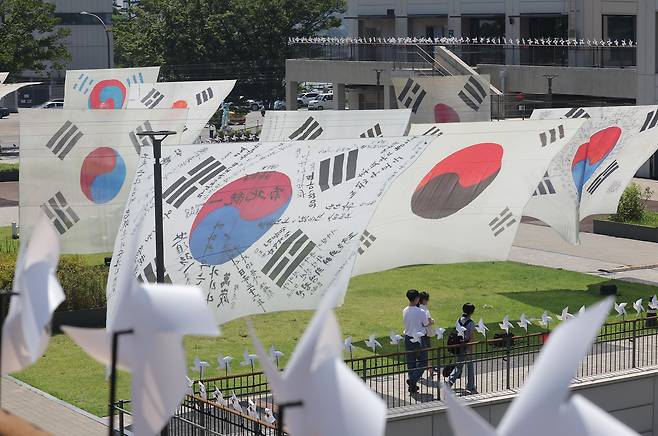 Large period reproductions of the South Korean national flag, Taegeukgi -- including designs used during the independence movement against Japan's 1910-45 colonial rule -- flutter in the wind on Nodeul Island in Seoul, in this photo taken Aug. 10, 2025, ahead of the 80th anniversary of the country’s liberation from Japanese colonization. (Yonhap)