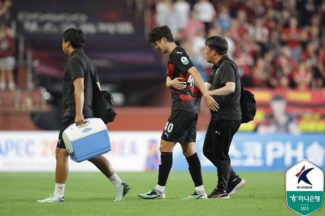 허리를 감싸며 그라운드를 빠져나가고 있는 기성용. 사진=한국프로축구연맹