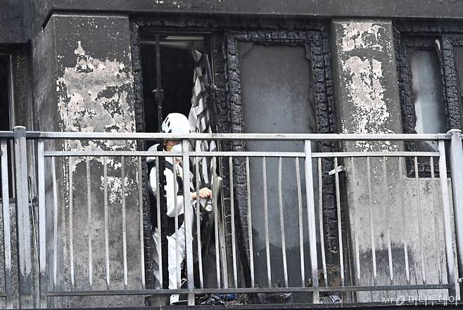 [광명=뉴시스] 김종택 기자 = 경찰과 소방 및 국립과학수사연구원 등 관계자들이 18일 경기 광명시 아파트 화재현장에서 합동감식을 하고 있다.   앞서 지난 17일 오후 9시5분께 이 아파트 주차장 필로티 천장에서 불이나 1명이 숨지고 64명이 부상을 입었다. 2025.07.18. jtk@newsis.com /사진=김종택