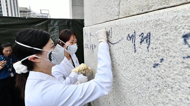 국립고궁박물관 전문가들이 낙서를 지우는 모습