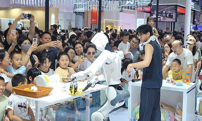 9일 베이징에서 열린 ‘세계로봇콘퍼런스(WRC)’에서 관람객들이 중국 로봇 기업 매직랩의 휴머노이드 로봇 시연을 보고 있다.