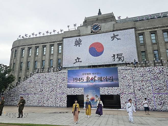지난 9일 서울 중구 서울광장에 태극기 바람개비로 꾸며진 6m 높이의 ‘태극기언덕’ 앞에서 독립 열사와 일본 순사 등으로 분장한 배우들이 광복해방 퍼포먼스 ‘1945 봄의 메아리’ 공연을 펼치고 있다.