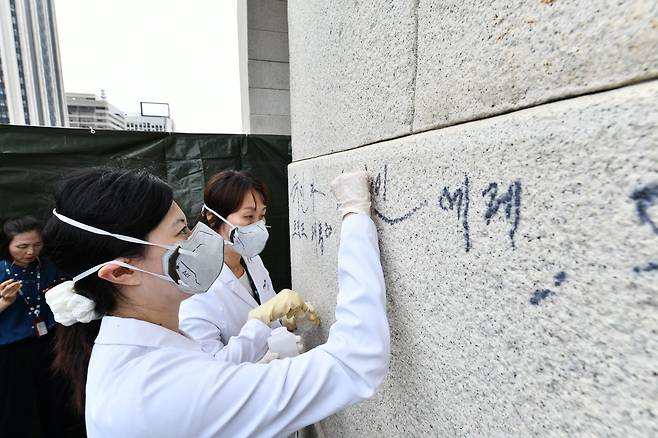 국립고궁박물관 전문가들이 낙서를 지우는 모습  [국가유산청 제공. 재판매 및 DB 금지]