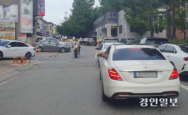 지난 11일 오후 6시께 야탑 먹자골목 유일의 공영주차장인 맛고을주차장이 이미 포화상태가 되면서 입구에 대기 차량들이 한 차선을 막고 서 있다. 2025.8.11 성남/김순기기자 ksg2011@kyeongin.com