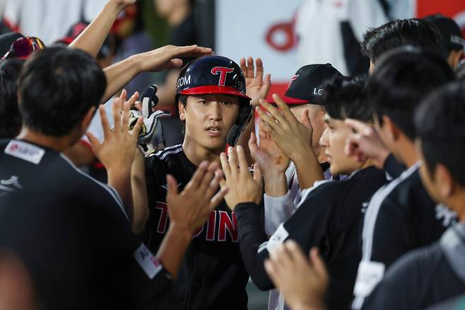 LG 구본혁이 12일 수원 KT전에서 득점한 후 동료들의 축하를 받고 있다. 구단 제공