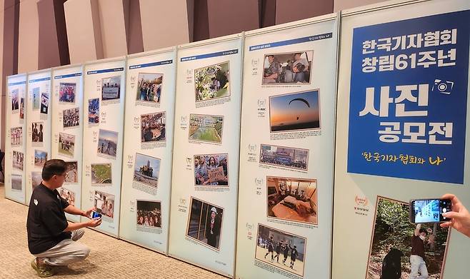 한국기자협회 창립 61주년 기념식 행사장엔 ‘기자협회와 나’ 사진 공모전에서 수상한 사진들이 전시됐다. 각각의 사진을 카메라에 담는 참석자들도 많았다. /김한내 수습기자