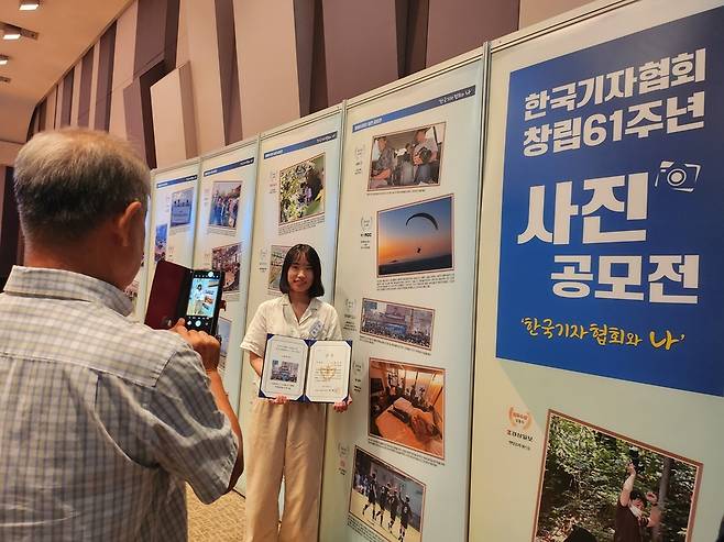 남영진 전 KBS 이사장이 12일 우수상을 수상한 최주연 한국일보 기자의 사진을 찍어주고 있다. 한국일보 출신인 남 이사장은 최 기자의 ‘직속 선배’다. /김한내 수습기자