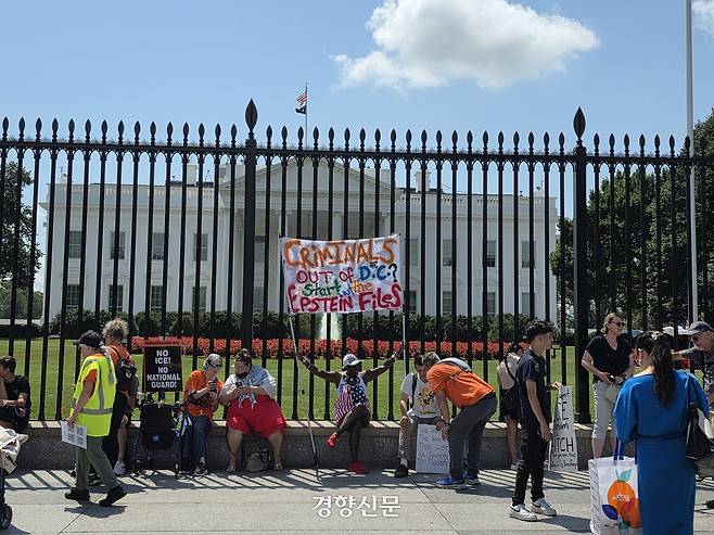 11일(현지시간) 미국 워싱턴 백악관 앞에서 시민들이 현수막과 팻말을 들고 1인 시위를 하고 있다.  워싱턴 | 정유진 특파원