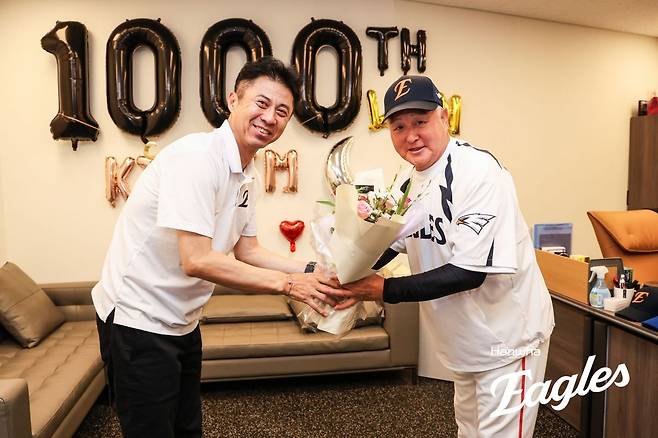 12일 롯데전에서 통산 1000승을 달성한 김경문(오른쪽) 한화 이글스 감독이 손혁 한화 단장에게 꽃다발을 선물받고 있다. 한화 제공