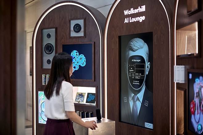 ‘워커힐 AI 라운지’에서 AI 매니저 ‘해리스’ 안내를 받아 아트 미션에 참여하고 있는 고객 / 사진=워커힐 호텔앤리조트