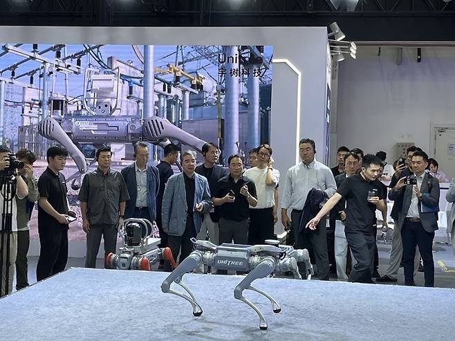 장재훈 현대차그룹 부회장이 지난 11일 중국 베이징 이좡 경제기술개발구에서 열린 세계로봇컨퍼런스(WRC)에 참석해 중국 대표 로봇 기업인 유니트리의 부스를 찾아 4족보행 로봇을 살펴봤다. [베이징 = 송광섭 특파원]