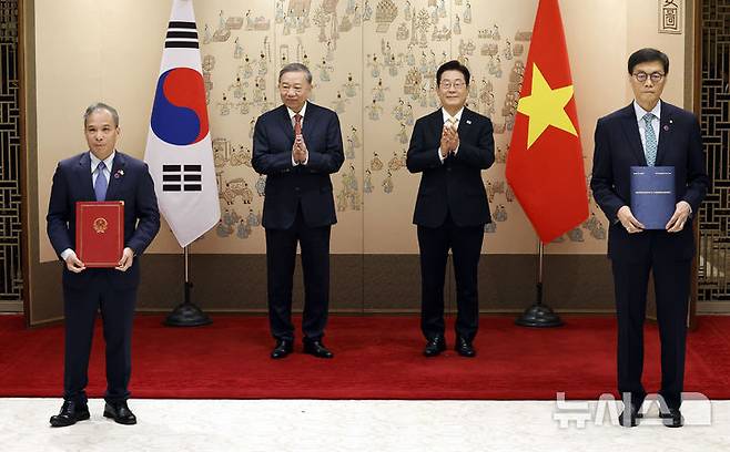 [서울=뉴시스] 최동준 기자 = 이창용 한국은행 총재와 또안 타이 썬 중앙은행 부총재보가 11일 서울 용산 대통령실 청사에서 이재명 대통령과 또 럼 베트남 당 서기장이 임석한 가운데 열린 양해각서(MOU) 서명식에서 중앙은행 간 협력 MOU에 서명 뒤 기념촬영을 하고 있다. 2025.08.11. photocdj@newsis.com