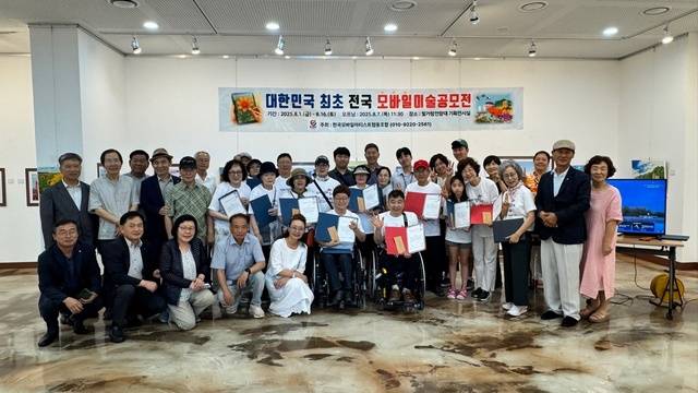 전남 나주 빛가람 전망대 1층 전시관에서 ‘모바일 미술 공모전’ 전시회가 16일까지 열린다. 공모전에 출품한 작가들이 7일 열린 개막식에서 기념촬영을 하는 모습.