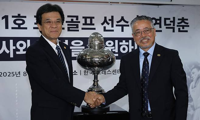 김원섭 KPGA 회장(오른쪽)과 야마나카 히로시 일본골프협회(JGA) 최고운영책임자(COO)가 12일 서울 중구 한국프레스센터에서 열린 ‘대한민국 1호 프로골프선수 고 연덕춘 역사와 전설을 복원하다’ 행사에서 다시 제작된 연덕춘의 일본오픈 우승 트로피 앞에서 악수하고 있다. 뉴시스