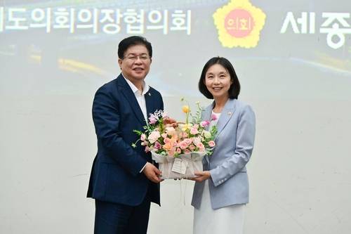 최호정(오른쪽) 서울시의회 의장이 제19대 대한민국시도의회의장협의회장에 선출된 후 축하 꽃바구니를 전달받고 있다. 사진 제공=서울시의회
