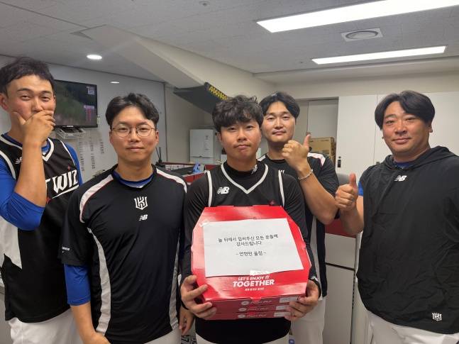 KT 트레이닝 파트가 12일 수원 LG전을 앞두고 안현민이 7월 월간 MVP 및 개인 첫 100안타 달성 기념으로 돌린 피자를 들고 기념 사진을 찍고 있다. /사진=KT 위즈 제공