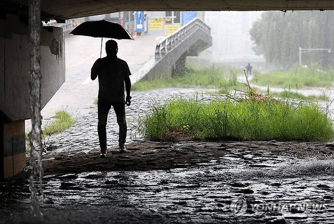 비 내리는 광주천변 (광주=연합뉴스) 조남수 기자 = 12일 오전 광주 북구 임동 광주천변에서 한 시민이 내리는 비에 우산을 쓰고 있다. 2025.8.12 iso64@yna.co.kr