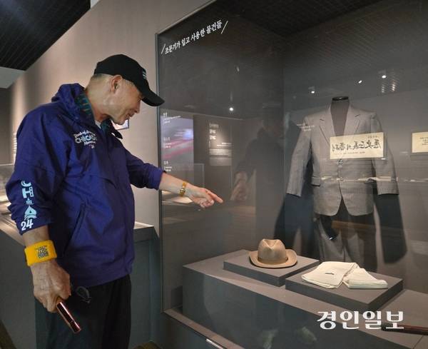 김석화씨가 화성독립운동기념관에 마련된 ‘조문기 선생 특별전시관’에서 조 선생이 생전 입었던 옷을 가리키고 있다. /김태강기자 think@kyeongin.com
