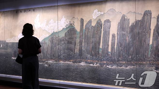 13일 서울 종로구 국립고궁박물관 2층 기획전시실에서 열린 특별전 '창덕궁의 근사謹寫한 벽화' 언론 공개회에서 참석자가 전시된 김규진 ‘총석정절경도’ 벽화를 살펴보고 있다. 국립고궁박물관은 14일부터 개관 20주년 특별전 '창덕궁의 근사謹寫한 벽화'에서 창덕궁 내전인 희정당, 대조전, 경훈각을 장식했던 벽화 6점을 최초로 일괄 공개한다. 2025.8.13/뉴스1 ⓒ News1 박지혜 기자