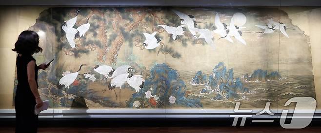 13일 서울 종로구 국립고궁박물관 2층 기획전시실에서 열린 특별전 '창덕궁의 근사謹寫한 벽화' 언론 공개회에서 참석자가 김은호 '백학도'를 살펴보고 있다. 국립고궁박물관은 14일부터 개관 20주년 특별전 '창덕궁의 근사謹寫한 벽화'에서 창덕궁 내전인 희정당, 대조전, 경훈각을 장식했던 벽화 6점을 최초로 일괄 공개한다. 2025.8.13/뉴스1 ⓒ News1 박지혜 기자
