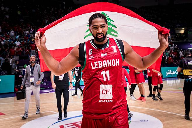 디드릭 로슨이 13일 일본과의 아시아컵 8강 결정전에서 승리한 뒤 레바논 국기를 들고 기뻐하고 있다. 미국 출신 귀화선수인 로슨은 이날 양팀 최다인 24점을 넣었다. /FIBA