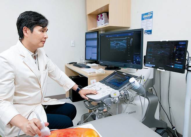 이광희 삼성창원병원 영상의학과 교수가 실리콘 인체 모형을 활용해 유방암 의심 부위를 초음파로 관찰하고 있다. 초음파 AI가 분석한 암 의심 부위의 악성도 등이 실시간으로 모니터에 나타나고 있다. 삼성창원병원 제공