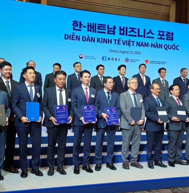 두나무와 베트남 밀리터리뱅크는 지난 12일 서울 롯데호텔에서 열린 '한·베트남 비즈니스 포럼'에서 기술 제휴 양해각서(MOU)를 체결했다. 이날 오경석 두나무 대표(앞줄 왼쪽 첫번째)를 비롯해 한국과 베트남 양국 정부·기관·기업인들이 기념 촬영을 하고 있다. 두나무 제공