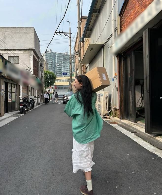 과거 인스타그램에 게시한 조민 씨의 모습. 골목길을 따라 상자를 메고 걸으며 웃고 있다. (본인 SNS 갈무리)