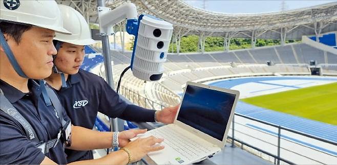 엔지니어들이 경기장에 인공지능(AI) 중계 카메라 ‘S1’을 설치한 뒤 점검하고 있다. S1 카메라는 4개의 렌즈가 독립된 영역을 촬영하고, AI 센서가 경기 중 움직이는 인물과 공 등을 추적하는 방식으로 실시간 중계를 할 수 있다.   /KT스카이라이프 제공