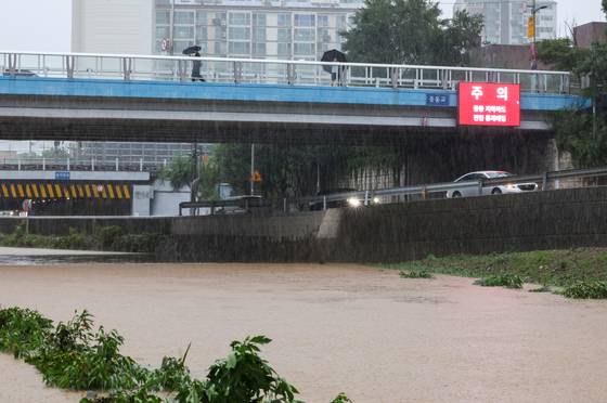 The road under Jeungsan Bridge in Seodaemun District, western Seoul, is fully closed on Aug. 13 due to heavy rain. [YONHAP]