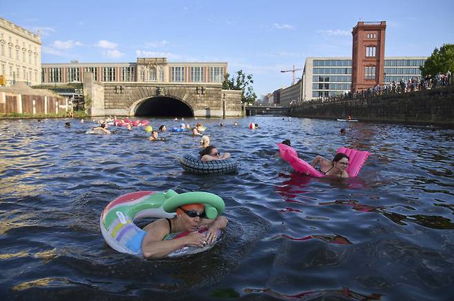 [베를린=AP/뉴시스] 12일(현지 시간) 독일 베를린에서 시민들이 슈프레강 수영 금지 해제를 촉구하며 강에서 수영하고 있다. 슈프레강은 수질 오염에 따른 보건 위험으로 100년 넘게 수영이 금지됐다. 시민 단체 등은 슈프레강이 수영할 만큼 수질이 개선됐다면서 수영 허용을 촉구하고 있다. 2025.06.18.