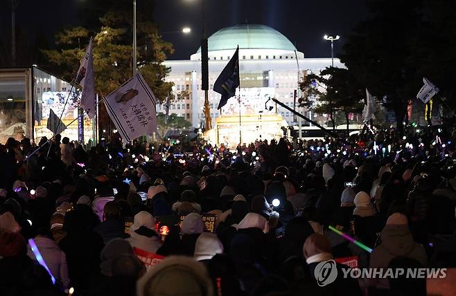 국회의사당 앞에서 이어지는 촛불집회 (서울=연합뉴스) 김성민 기자 = '윤석열 즉각 퇴진·사회대개혁 비상행동'이 13일 오후 서울 영등포구 국회의사당 인근에서 연 탄핵소추안 국회 통과 촉구 촛불집회에서 참가자들이 응원봉을 들고 구호를 외치고 있다. 2024.12.13 ksm7976@yna.co.kr