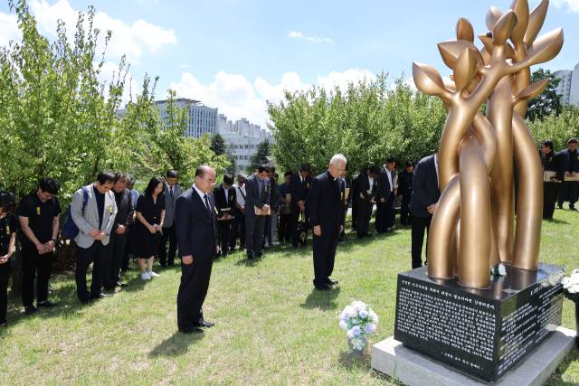 최재원(왼쪽) 부산대 총장과 송기인 고현철교수기념사업회 이사장이 14일 부산대 인문대 앞에 설치된 추모 조형물 앞에서 헌화하고 있다. 부산대 제공