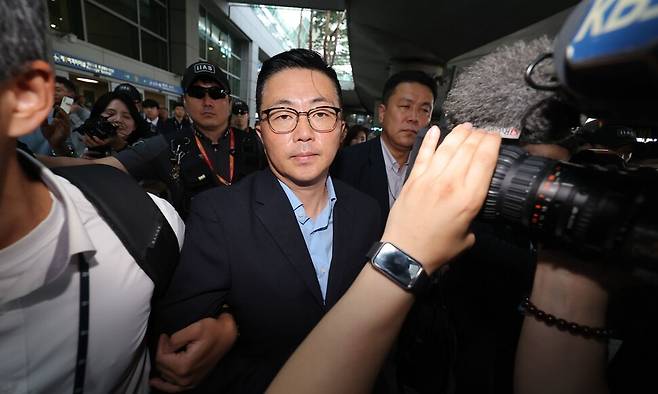 김건희 여사 일가의 \\\'집사\\\'로 지목된 김예성씨가 12일 인천국제공항 제1여객터미널을 통해 입국한 뒤 민중기 특별검사팀에 체포돼 이동하고 있다. 연합뉴스