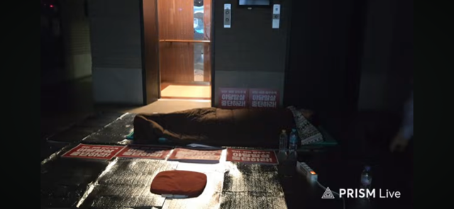 김문수 국민의힘 당대표 후보가 14일 새벽 서울 여의도 국민의힘 당사 로비 엘리베이터 앞에서 잠을 자고 있다. 유튜브 라이브 캡처