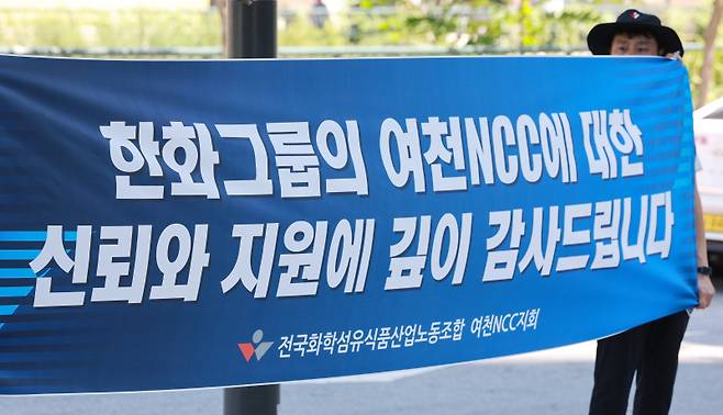 <yonhap photo-2614="">전국화학섬유식품산업노동조합 여천NCC지회 조합원이 12일 서울 중구 한화빌딩 앞에서 '한화그룹의 여천NCC에 대한 신뢰와 지원에 깊이 감사드립니다' 문구가 적힌 현수막을 들고 있다. 연합뉴스</yonhap>
