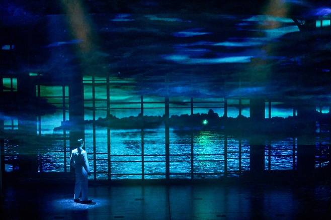뮤지컬 '위대한 개츠비'의 오프닝 장면. 개츠비가 초록색 불빛이 빛나는 옛 연이 데이지의 집을 바라보고 있다./사진=오디컴퍼니
